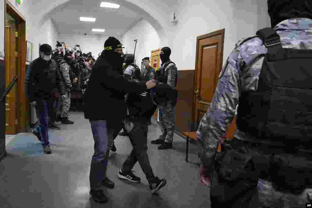 A suspect in the Crocus City Hall shooting on Friday, is escorted by police officers in the Basmanny District Court in Moscow, Russia, March 24, 2024.