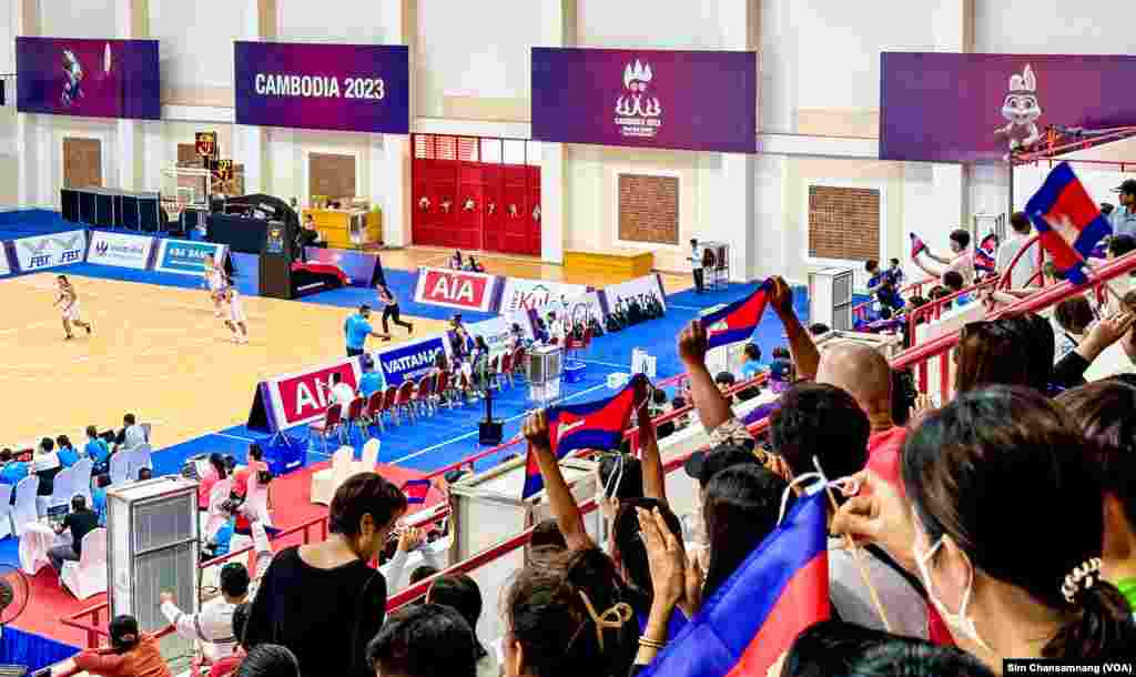 អ្នក​គាំទ្រ​របស់​កម្ពុជា​លើក​ទង់​ជាតិ​កម្ពុជា ក្នុង​ពេល​ប្រកួត​កីឡា​បាល់​បះ នារី នៃ​ការ​ប្រកួត​កីឡា​ស៊ី​ហ្គេម​លើក​ទី៣២ នៅ​ពហុកីឡ​ដា្ឋន​មរតក​តេជា ក្នុង​រាជធានី​ភ្នំពេញ នៅ​ថ្ងៃទី១៣ ខែឧសភា ឆ្នាំ២០២៣។ (ស៊ឹម ចាន់សំណាង/វីអូអេ)