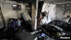 25일 이스라엘 군의 공습으로 붕괴된 가자지구 압둘파타 하무드 학교에 어린이들이 서있다.