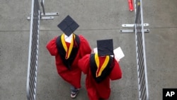 FILE - In this May 13, 2018, file photo, new graduates walk at the start of the Rutgers University graduation ceremony in New Jersey. Americans are saying the U.S. higher education system is headed in the “wrong direction.” (AP Photo/Seth Wenig, File)