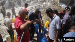 8일 가자 지구 북부 자발리아 난민 캠프에서 수질 오염과 부족으로 어려움을 겪고 있는 가운데 팔레스타인 난민들이 용기에 물을 채우고 있다.