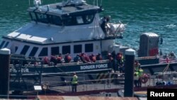 Orang-orang yang diyakini migran, turun dari kapal Pasukan Perbatasan Inggris setibanya di Pelabuhan Dover di Inggris, 29 April 2024. (REUTERS/Chris J. Ratcliffe)