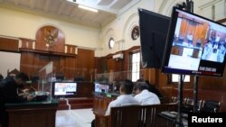 Ketua Panitia Penyelenggara pertandingan Arema FC melawan Persebaya Surabaya, Abdul Haris dan Petugas Keamanan Suko Sutrisno menghadiri pembacaan putusan di pengadilan di Surabaya, Jawa Timur, 9 Maret 2023. (REUTERS/Prasto Wardoyo)