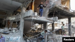 Des Palestiniens quittent une maison touchée par une frappe israélienne, à Rafah, dans le sud de la bande de Gaza, le 9 mai 2024. (REUTERS/Hatem Khaled)