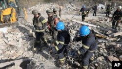 In this photo provided by the Ukrainian Presidential Press Office, emergency workers search the victims of the deadly Russian rocket attack that killed more than 40 people in the village of Hroza near Kharkiv, Ukraine, Oct. 5, 2023. 