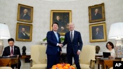 조 바이든 미국 대통령과 윤석열 한국 대통령이 26일 백악관 정상회담에 앞서 집무실에서 악수를 나누고 있다.