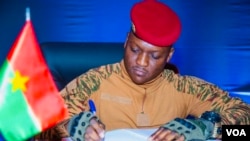 Le Capitaine Ibrahim Traoré signant la charte prolongeant la Transition de cinq ans, Ouagadougou, le 27 mai 2024 (VOA/Lamine Traoré)
