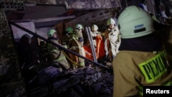 Petugas pemadam kebakaran membawa kantong jenazah korban pasca kebakaran meluluhlantakkan depo penyimpanan Pertamina di Jakarta Utara Jumat malam (3/3). Api mulai padam dan para petugas pemadam kebakaran mulai melakukan pendinginan.