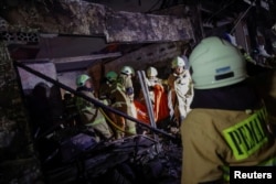 Petugas pemadam kebakaran membawa kantong jenazah korban kebakaran terjadi di stasiun penyimpanan bahan bakar yang dioperasikan oleh Pertamina, di Plumpang, Jakarta, 3 Maret 2023. (REUTERS/Willy Kurniawan)