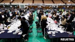 10일 한국 서울에서 열린 제22대 국회의원 선거에서 중앙선거관리위원회 관계자들이 투표 용지를 개표하고 있다.