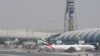 FILE - An Emirates jet waits at the gate as another prepares to land in Dubai, United Arab Emirates, on Aug. 17, 2022, shortly before the airline suspended flights to Nigeria. Nigerian authorities on Sept. 12, 2023, announced that the UAE would lift a year-old visa ban.