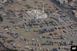 Deretan bus menunggu para jemaah haji di parkiran, saat menunaikan ibadah haji tahunan di Mina, dekat kota suci Mekkah, Arab Saudi, Senin, 17 Juni 2024. (AP/Rafiq Maqbool)