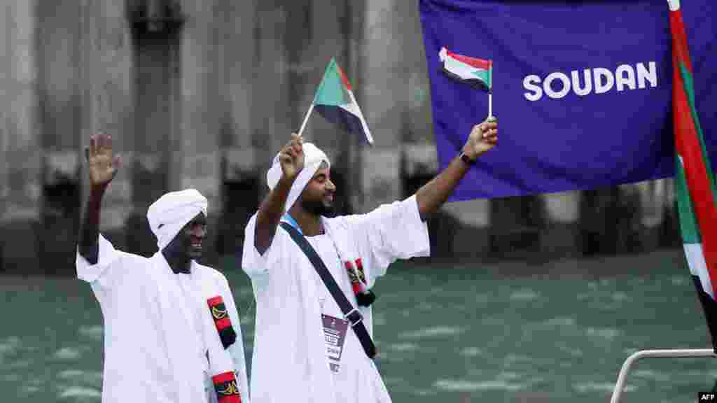Athletes in the delegation of Sudan wave flags aboard a boat in the floating parade on the river Seine during the 2024 Olympics opening ceremony in Paris, July 26, 2024.