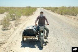 A man rides in desert that used to be part of the bed of the Aral Sea, outside Muynak, Uzbekistan, June 26, 2023.