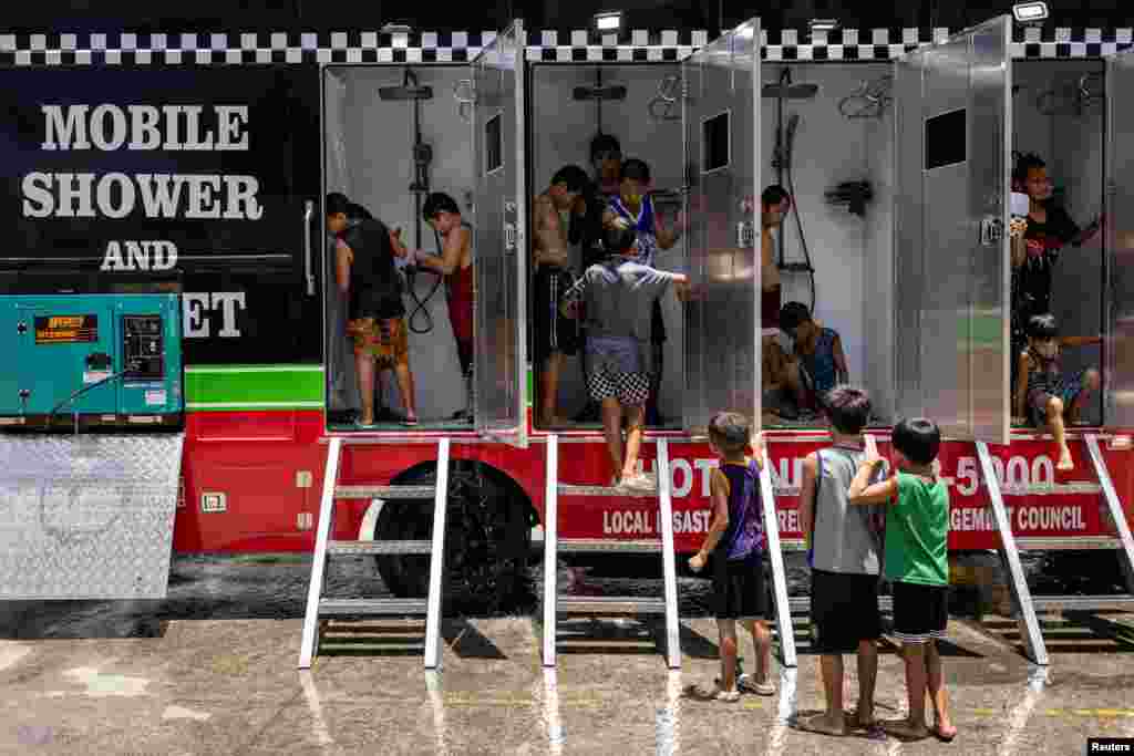 Children use a mobile shower provided by the local government amid extreme heat in Valenzuela, Metro Manila, Philippines, May 2, 2024.