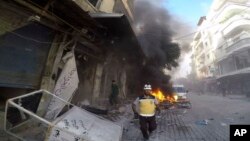 A civil defense worker runs at the site where a shell hit west of Idlib city, Syria, Oct. 5, 2023. The government shelled Idlib province villages after drones hit a ceremony for new military officers in Homs, killing and wounding dozens. (Syrian White Helmets via AP)