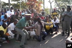 Male prisoners accompanied by prison guards celebrate after being released from Chikurubi maximum prison on the outskirts of Harare, Zimbabwe, May, 19, 2023.