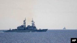 In this photo released by the Taiwan Ministry of National Defense, Taiwan guided missile destroyer Ma Kong DDG1805, left, monitors Chinese guided missile destroyer Xi'an DDG15, right, near Taiwan on May 23, 2024. 