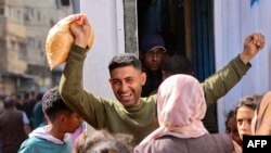 A Palestinian man reacts after buying subsidized bread outside a bakery in Gaza City on April 14, 2024.