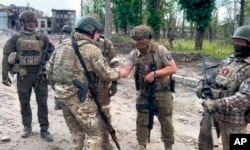 Kepala tentara bayaran Grup Wagner, Yevgeny Prigozhin, menyalami tentaranya di Bakhmut, Ukraina, Sabtu, 20 Mei 2023. (Foto: Prigozhin Press Service via AP)