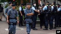 Police officers stand guard outside the West Kowloon Magistrates' Courts in Hong Kong, May 30, 2024.