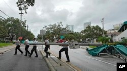 Members of the Tampa Fire Rescue Dept., remove a street pole brought down during Hurricane Idalia Wednesday, Aug. 30, 2023, in Tampa, Florida. (AP Photo/Chris O'Meara)