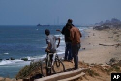 Brod se vidi u daljini u blizini plutajućeg pristaništa koje bi trebalo da služi za distribuciju pomoći, gledano iz centralnog Pojasa Gaze, 16. maja 2024.