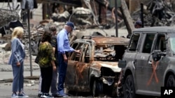 President Joe Biden and first lady Jill Biden look at a burned car with Hawaii Gov. Josh Green and his wife Jaime Green as they visit areas devastated by the Maui wildfires, Aug. 21, 2023, in Lahaina, Hawaii. 
