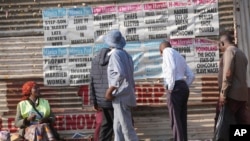 People read newspaper headlines on the streets of Harare, Zimbabwe, Aug. 25, 2023. 