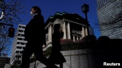 Pedestrians walk past the Bank of Japan building in Tokyo, Japan March 18, 2024. 
