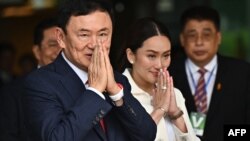 Mantan Perdana Menteri Thailand Thaksin Shinawatra menyapa pendukungnya bersama putri bungsunya Paetongtarn Shinawatra (kanan) setelah mendarat di Bandara Don Mueang Bangkok pada 22 Agustus 2023. (Foto: AFP)