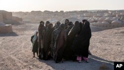 Afghan women mourn relatives killed in an earthquake at a burial site after an earthquake in Zinda Jan district, western of Afghanistan, Oct. 8, 2023. 
