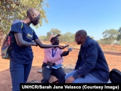 In this undated image provided by UNHCR, Assistant High Commissioner for Operations Raouf Mazou speaks with radio journalist Jabrallah Tia.