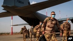 FILE - French soldiers disembark from a US Air Force C130 cargo plane at Niamey, Niger, base, on June 9, 2021. 