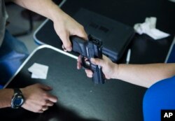 Seorang pria Israel membeli senjata di toko senjata dekat pemukiman Yahudi di Tepi Barat, Givat Zeev, Minggu, 11 Oktober 2015. (AP/Dan Balilty)