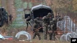 FILE - Polish soldiers install a razor wire barrier along Poland's border with the Russian exclave of Kaliningrad in Wisztyniec, Poland, Nov. 2, 2022. 