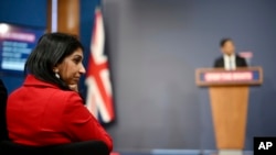 Menteri Dalam Negeri Inggris Suella Braverman mendengarkan keterangan Perdana Menteri Rishi Sunak dalam konferensi pers di Downing Street, London, Selasa, 7 Maret 2023. (Leon Neal/Pool via AP)