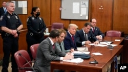 ອະດີດປະທານາທິບໍດີ ສະຫະລັດ ທ່ານດໍໂນລ ທຣຳ, ກາງ, ປາກົດຕົວຢູ່ໃນສານສຳລັບການຮັບຟັງຄຳຟ້ອງ ຕໍ່ທ່ານ, ວັນທີ 4 ເມສາ 2023, ໃນນະຄອນນິວຢອກ. ທ່ານທຣຳ ໄດ້ສ້າງປະຫວັດສາດ ໂດຍມີກຳນົດຈະເລີ້ມຄະດີອາຍາ ໃນວັນຈັນນີ້. 