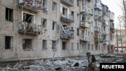 지난 27일 우크라이나 하르키우의 경찰관이 러시아군의 공격으로 무너진 아파트를 조사하고 있다. (자료화면)