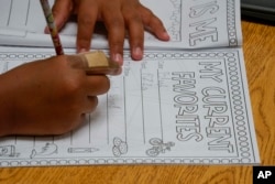 FILE - Aaliyah Ibarra works on her memory book during the last week of classes at Frye Elementary School in Chandler, Arizona Tuesday, May 23, 2023. (AP Photo/Darryl Webb)
