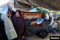 A Palestinian woman, who fled her house amid Israeli strikes, shelters at a U.N.-run center after Israel's call for more than 1 million civilians in northern Gaza to move south, in Khan Younis in the southern Gaza Strip, Oct. 18, 2023.
