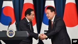 2023年5月7日，韩国总统尹锡悦和日本首相岸田文雄在首尔韩国总统办公楼举行双方会谈后召开的联合记者会上相互握手致意。