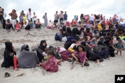 Pengungsi Rohingya beristirahat di pantai Lampanah Leungah setelah mendarat di Aceh Besar, Provinsi Aceh, Kamis, 16 Februari 2023. (AP/Riska Munawarah)