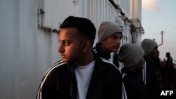 Migran asal Bangladesh tampak menyaksikan matahari terbenam dari atas dek kapal Ocean Viking menyusul operasi penyelamatan yang dilakukan di lepas pantai Malta, pada 21 Mei 2024. (Foto: AFP/Clément Melki)