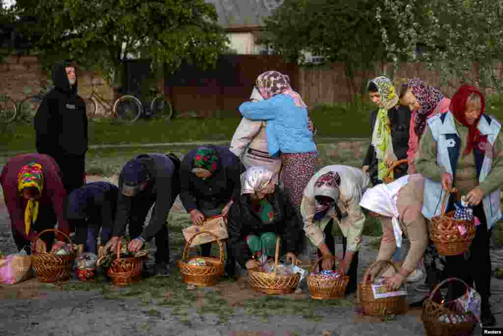 Believers pick up their Easter baskets after they were blessed by a priest during an Orthodox Easter service in the village of Krasne, Chernihiv region, Ukraine, May 5, 2024. 
