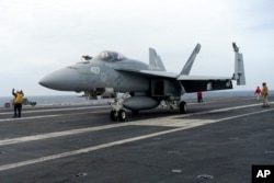 Sebuah F-18E parkir di dek penerbangan kapal induk USS Theodore Roosevelt, Kamis, 11 April 2024 selama latihan angkatan laut gabungan selama tiga hari oleh A.S., Jepang dan Korea Selatan di Laut Cina Timur. (AP/Mari Yamaguchi)