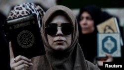 튀르키예 이스탄불 주재 스웨덴 영사관 밖에서 코란 소각 항의 시위에 참가한 여성이 코란을 들어 보이고 있다. (자료사진)