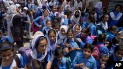 Students leave after attending school as authorities announced reduced classroom hours due to soaring temperatures, in Lahore, Pakistan, May 21, 2024.