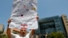 FILE - An anti-Hezbollah protester holds a banner during a sit-in in Beirut, Lebanon, July 24, 2020.