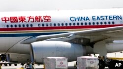 FILE - A carter drives past a China Eastern airliner parked at the Beijing International Airport in Beijing on Aug. 29, 2007.